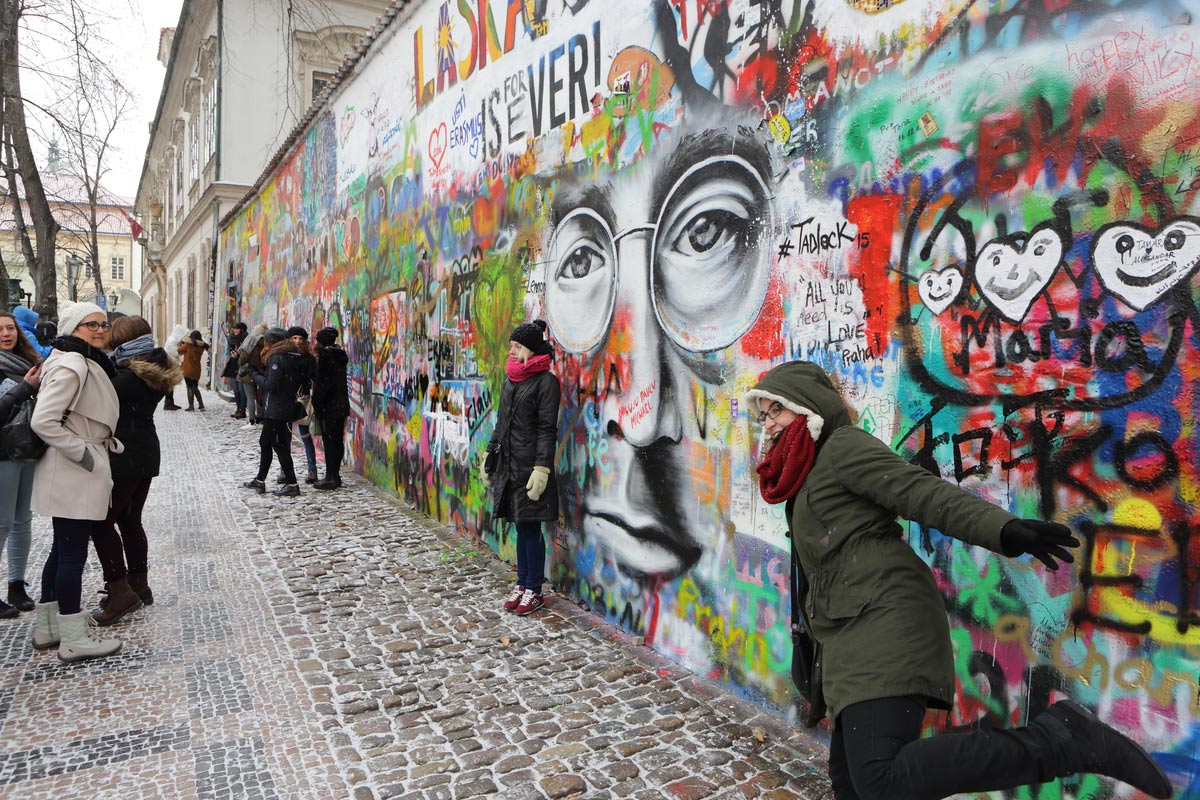 Happy tourists snapping a few amazing pictures at the Lennon wall