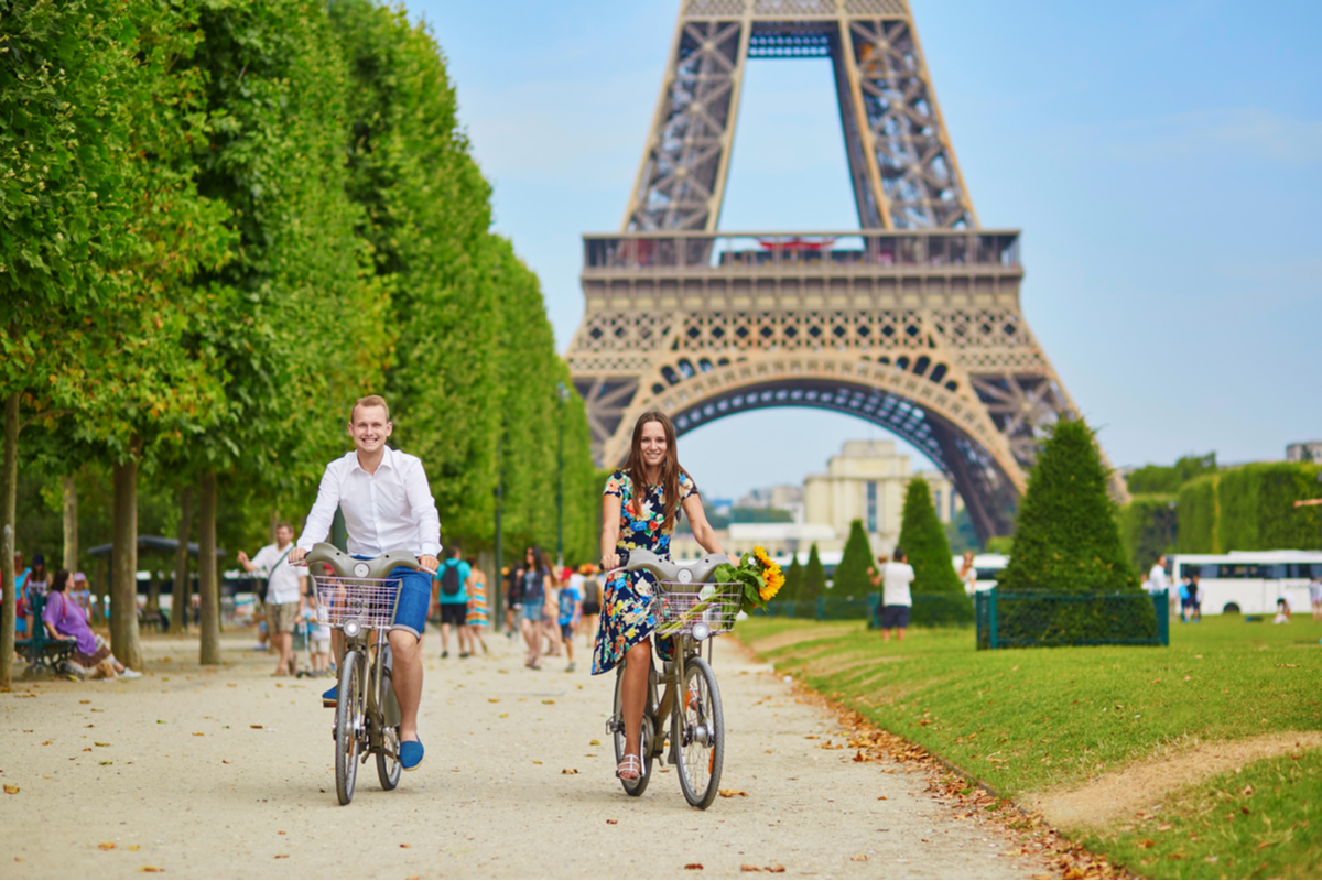 Couple riding bikes in Paris, France Valentine's Day