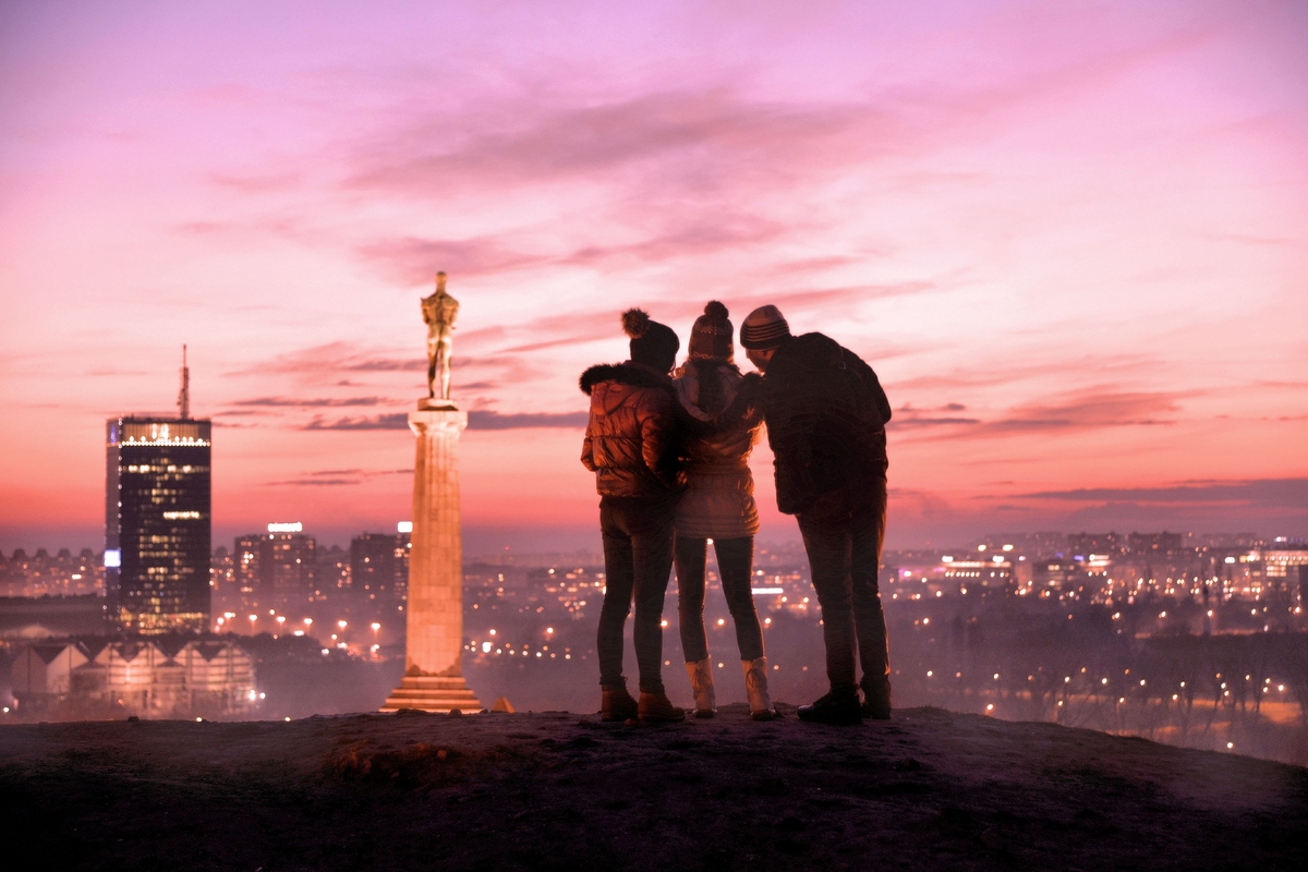 Group of people admire sunset views of Belgrade travelling to Serbia