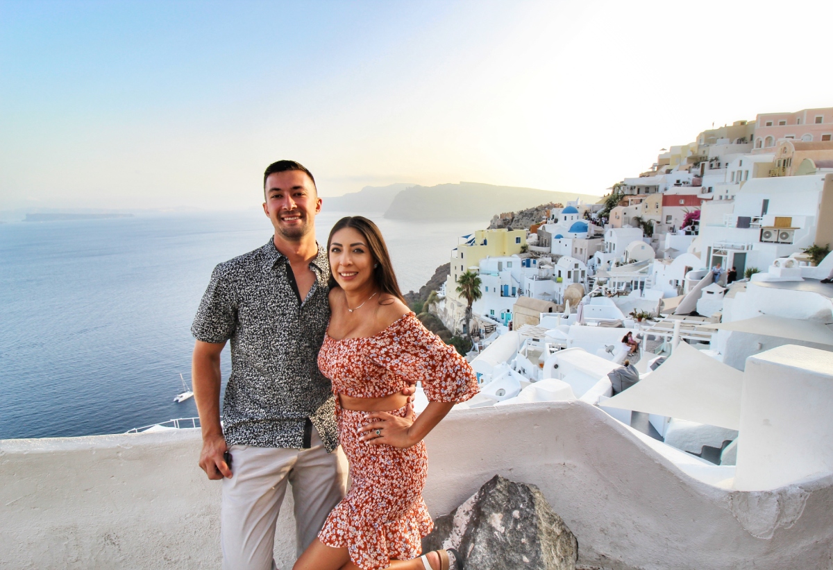 Couple sightseeing in Santorini, Greece, at sunset 